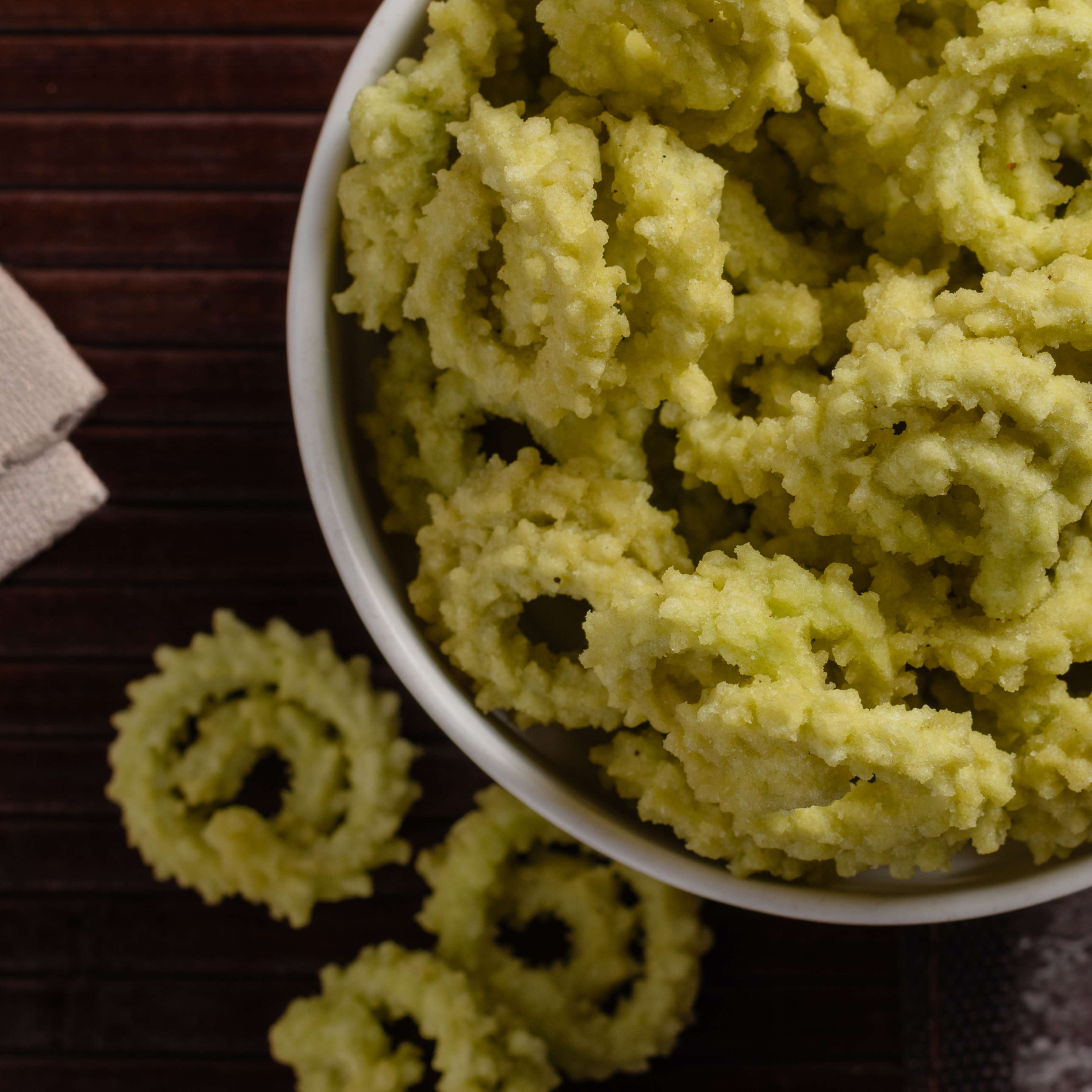 Buy Palak Chakli snack online from World of Mysore Pak – green murukku with a hint of leafy freshness and traditional taste.